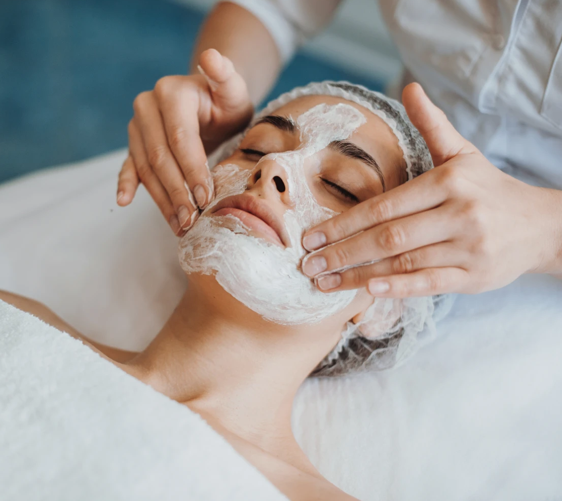 Woman receiving facial mask treatment at spa